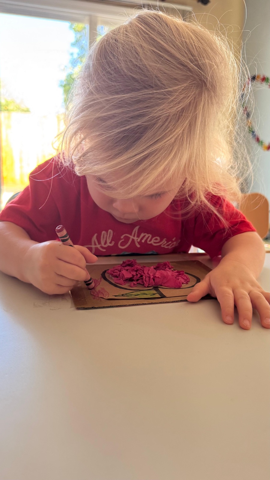 Child focused on a hands-on art project at Ale's Home Childcare