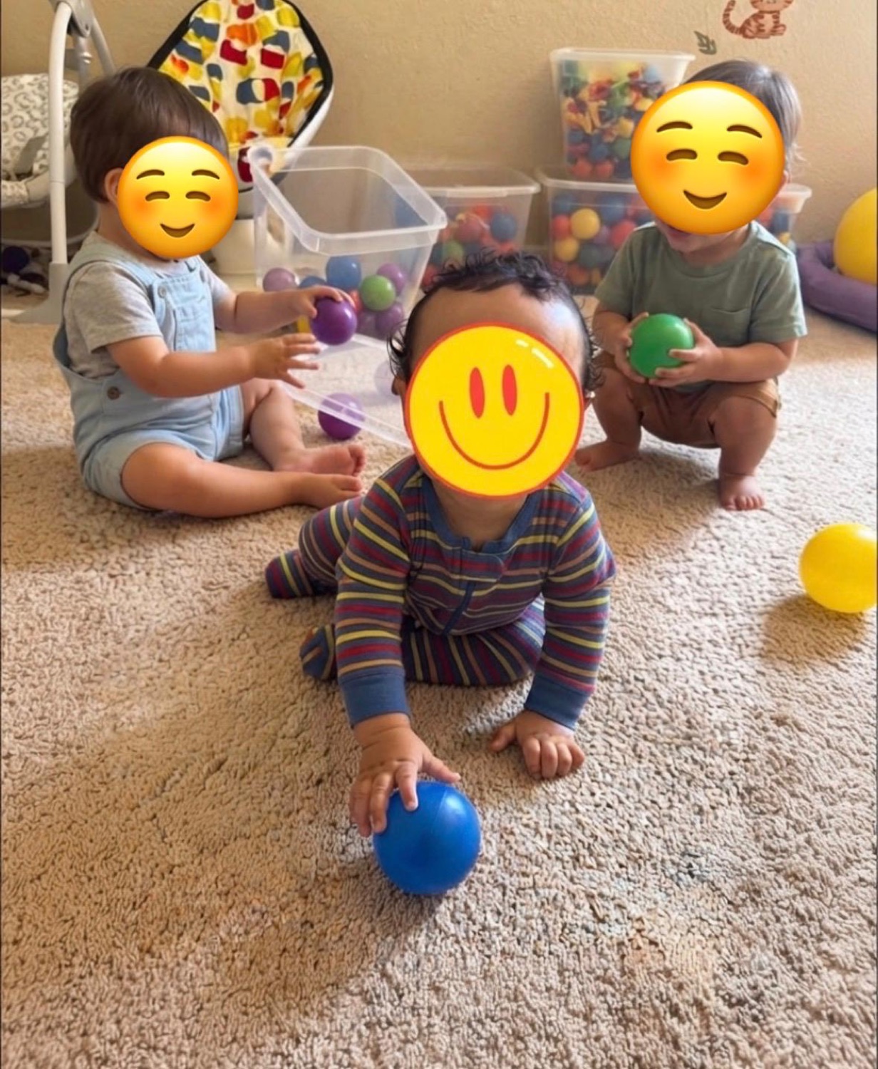 Children playing together with colorful balls with faces covered for privacy