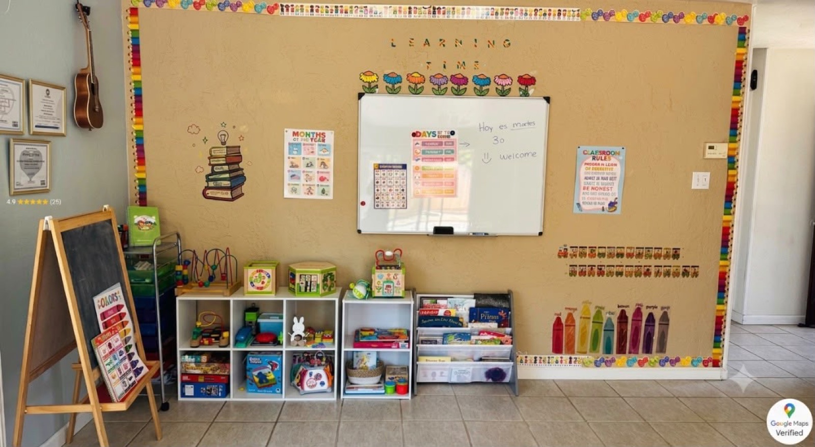 Learning wall with a whiteboard, books, toys, and colorful classroom materials