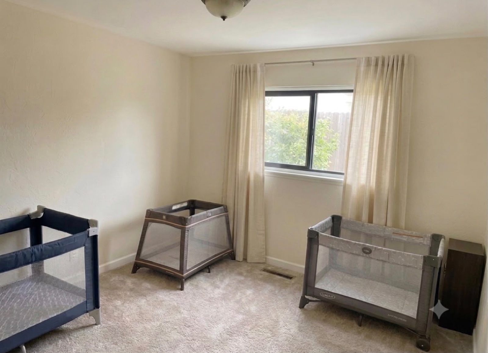 Clean quiet nap room with pack and play cribs near a window